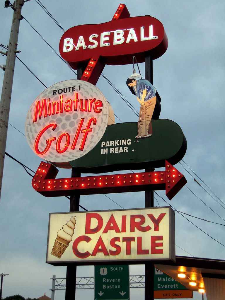 The Route 1 Miniature Golf neon sign with a golfer, a baseball arrow and the Dairy Castle sign below