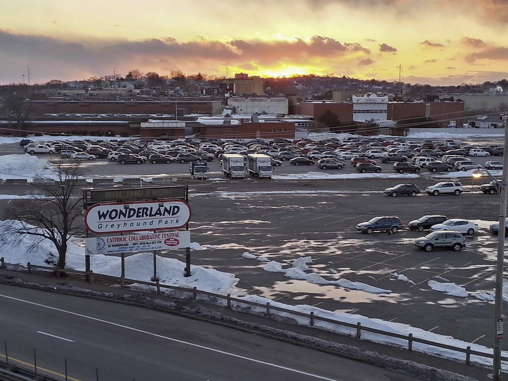 The Wonderland Greyhound Park sign over a snowy parking lot at sunset